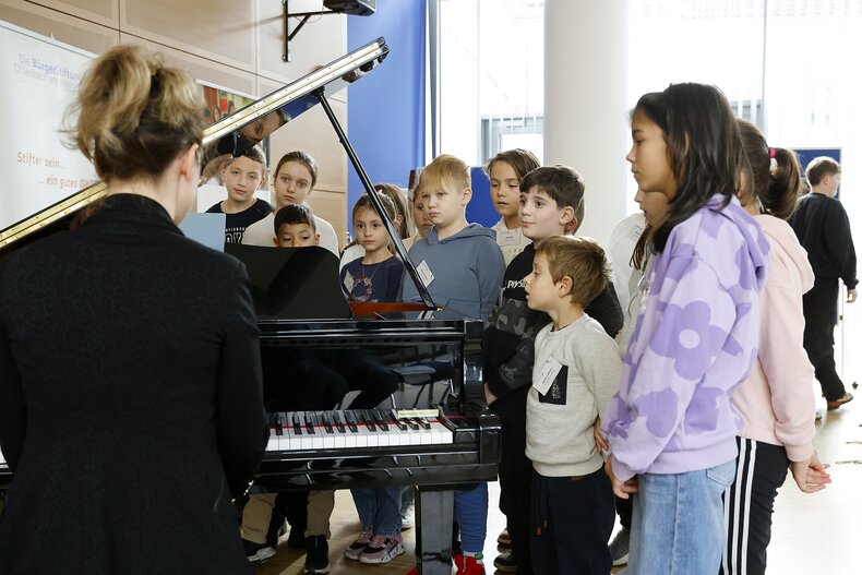 Klavierlehrerin Ioana Delioran erklärt den Aufbau eines Klaviers und spielt ein Stück von Debussy. | © DWS - Bürgerstiftung Offenbach